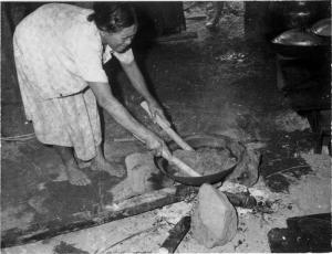 族人用木棍攪拌正在煮的麻線